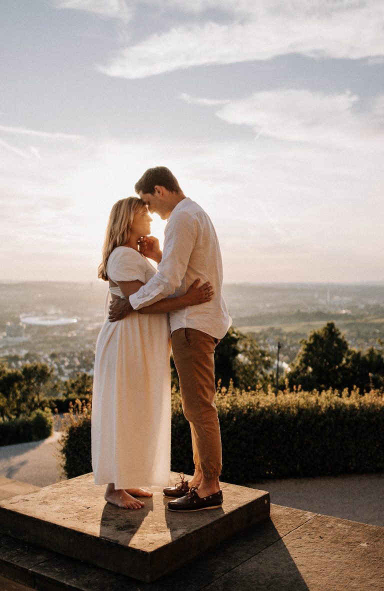 Schwangere Frau und Partner romantisch im Gegenlicht, liebevoller Moment, weite Aussicht | Pregnancy Shootings by Kathy Audrey Photography.