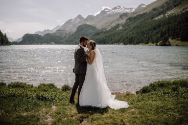 Brautpaar steht sich eng gegenüber vor einer wunderschönen Bergkulisse am Silchersee in Sils Maria