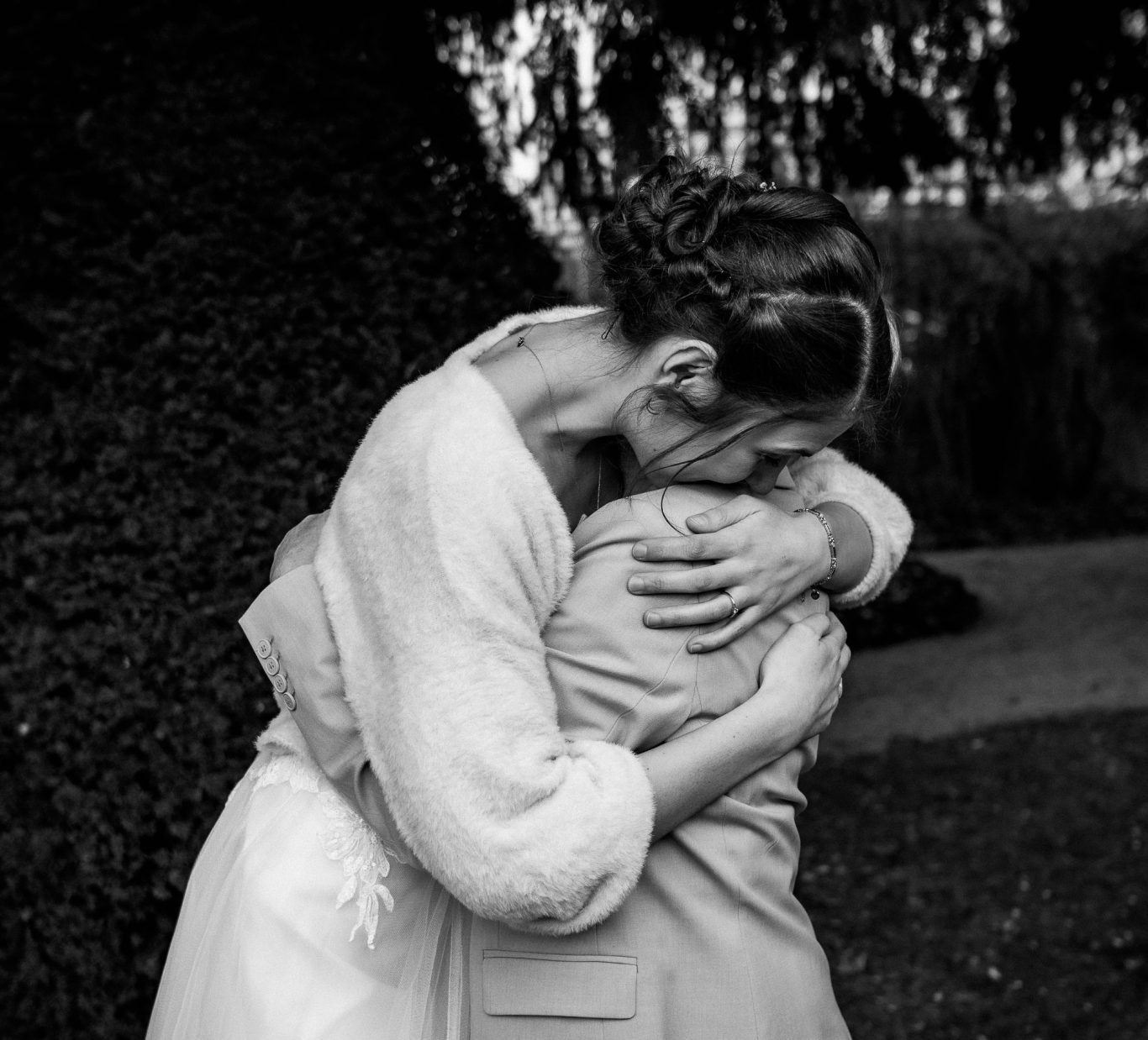Emotionale Schwarz-Weiß-Aufnahme: Eine Braut umarmt liebevoll ihre Mutter, eingefangen von Kathy Audrey Photography.